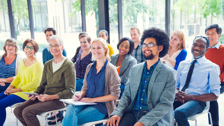 A group of people sitting in a conference room.