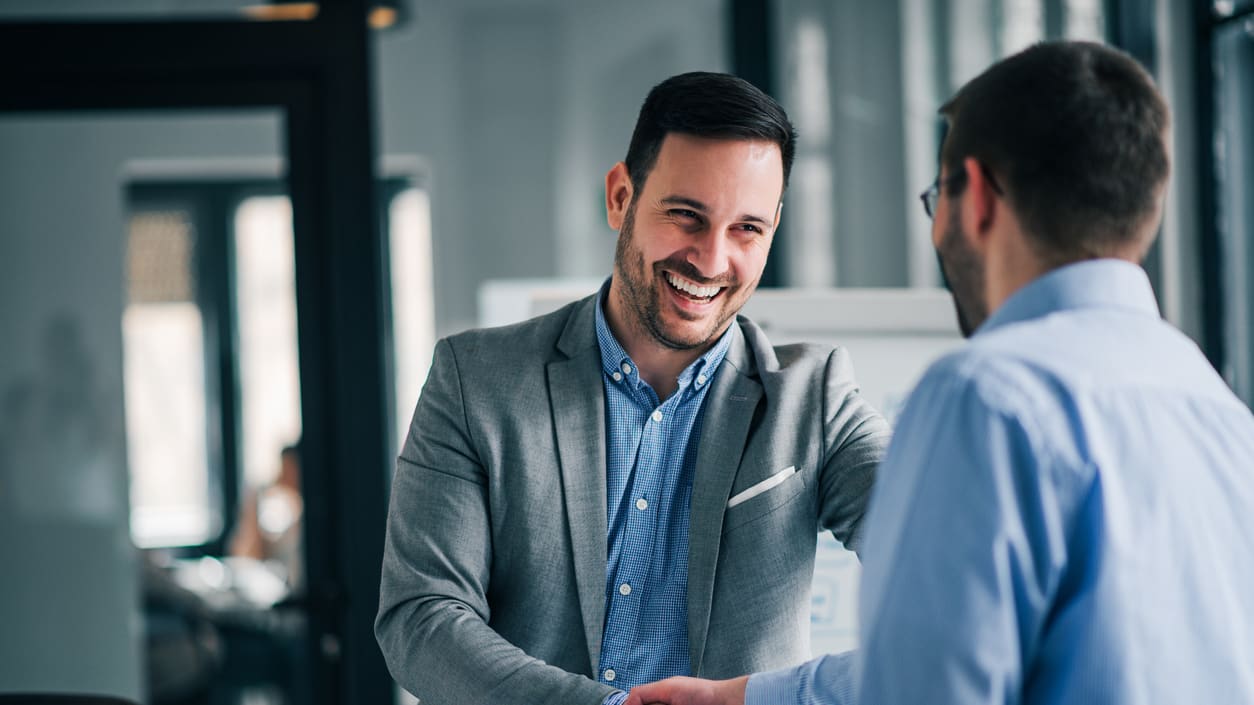 Two businessmen shaking hands in an office.