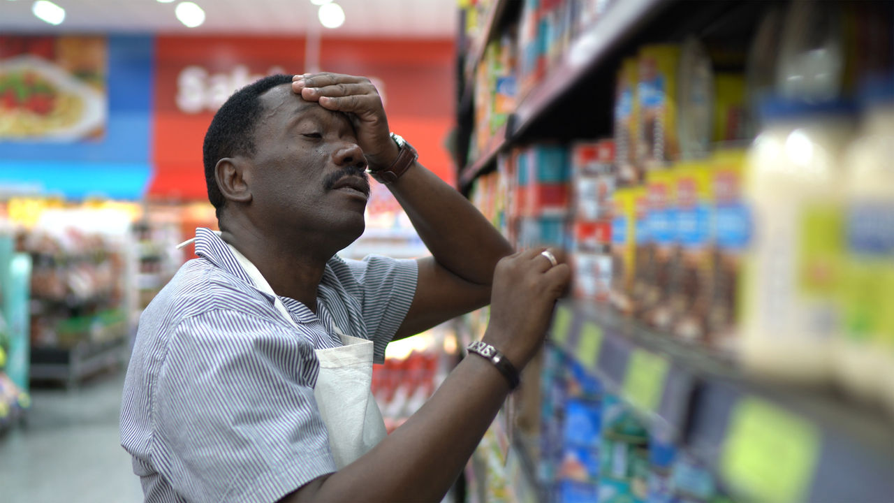 black worker stressed in grocery store