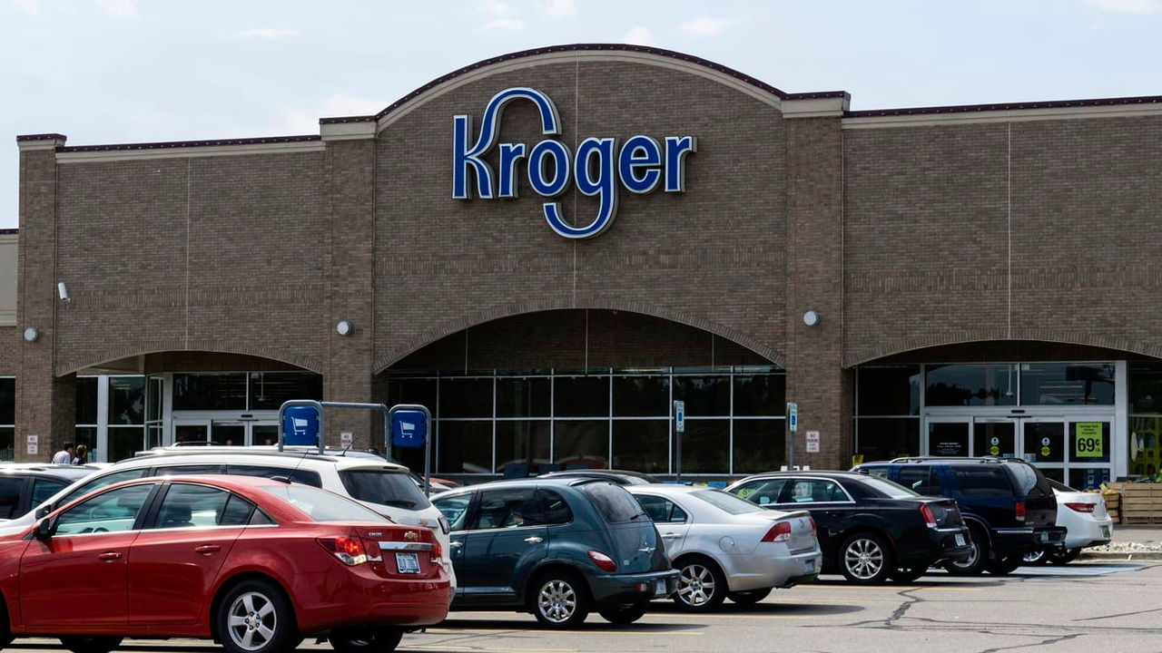 A kroger store with cars parked in front of it.