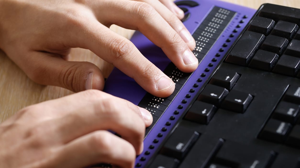 A person is typing on a purple keyboard.