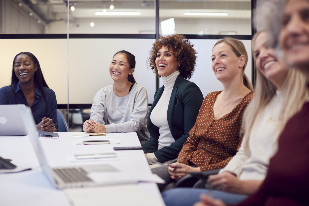 diverse group of women smiling and laughing at work