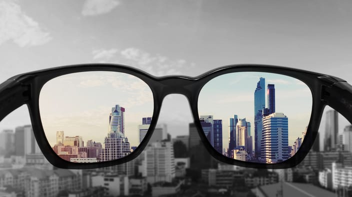 A pair of glasses with a view of a city.