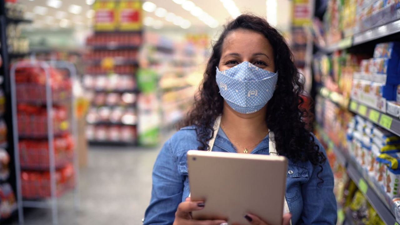 A woman wearing a face mask in a grocery store.