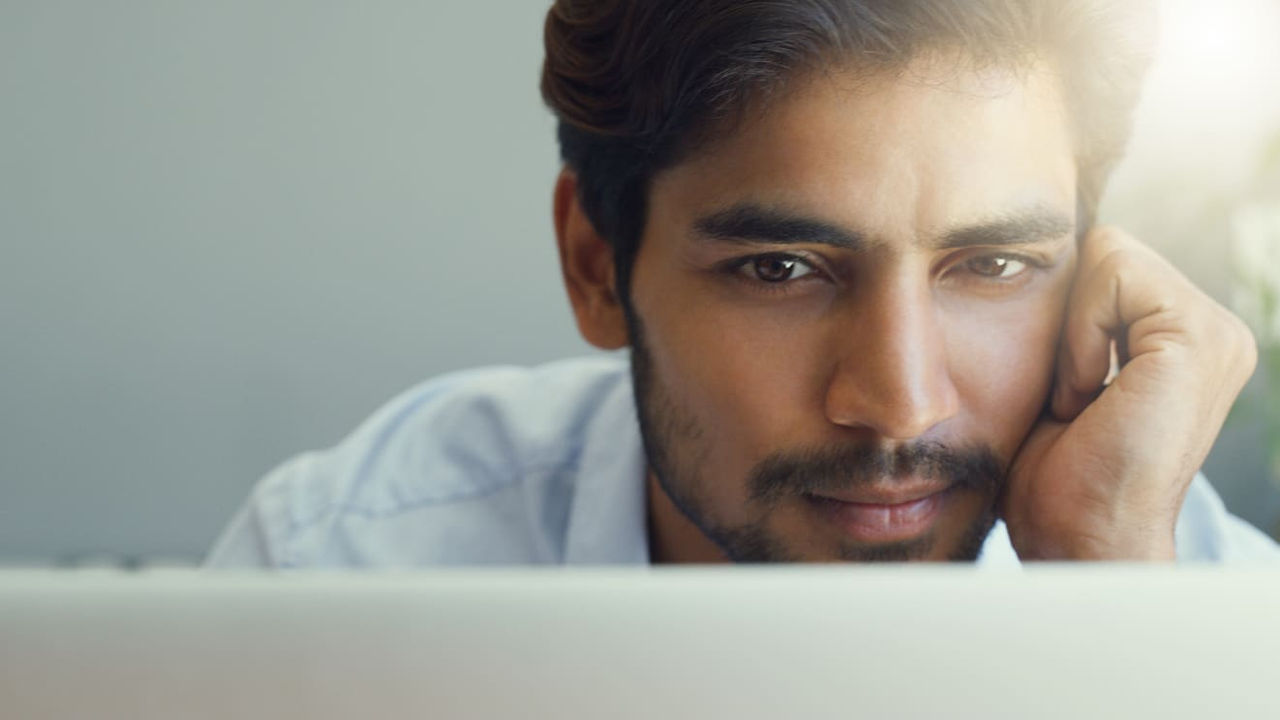 A man looking at his laptop screen.