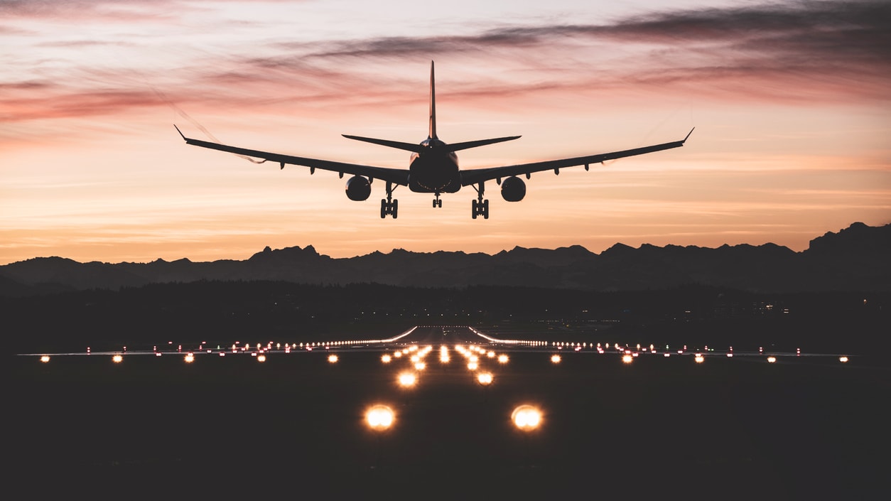 An airplane is taking off on an airport runway at dusk.