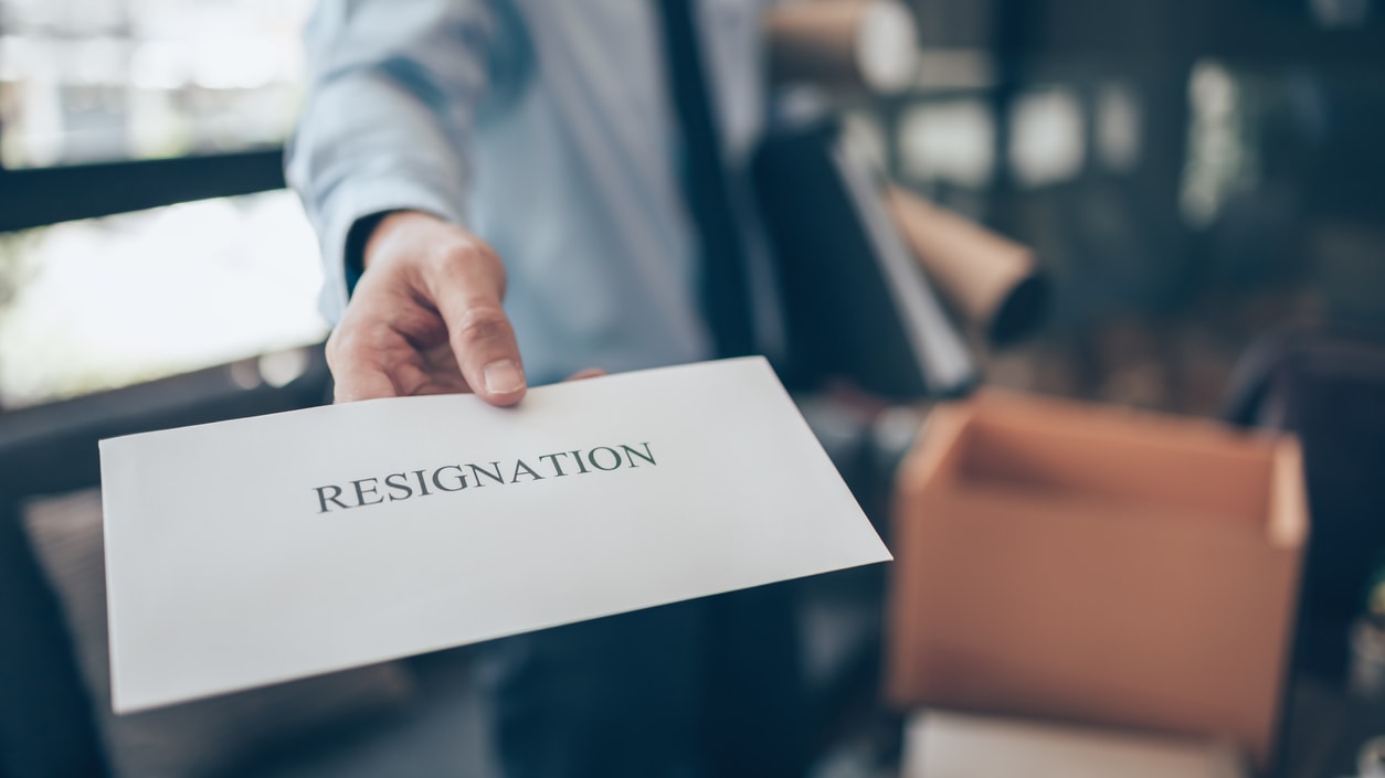 A man holding a letter with the word resignation.