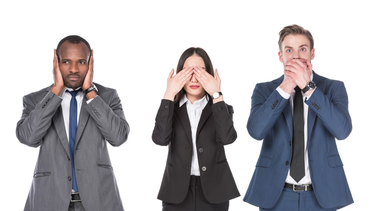A group of business people covering their eyes with their hands.