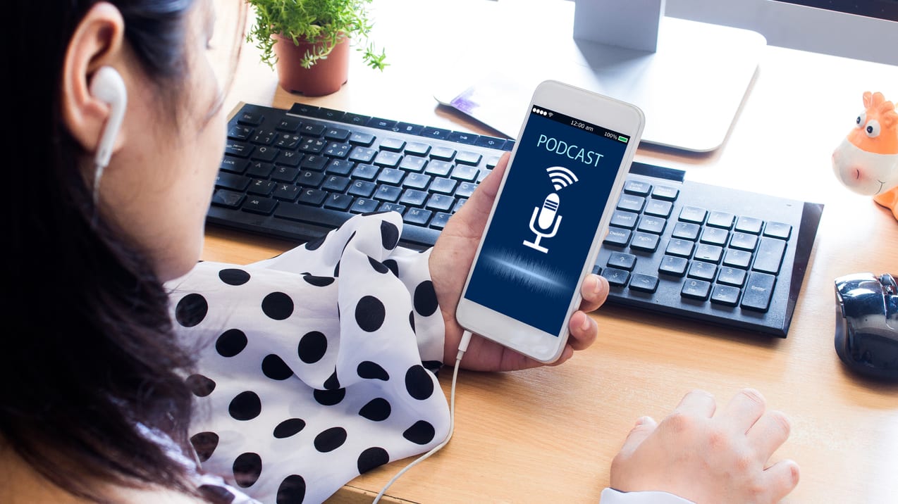 A woman is holding a phone and listening to music.