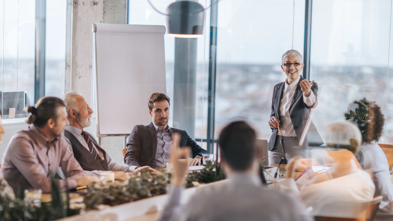 A businessman giving a presentation to a group of people in a conference room.