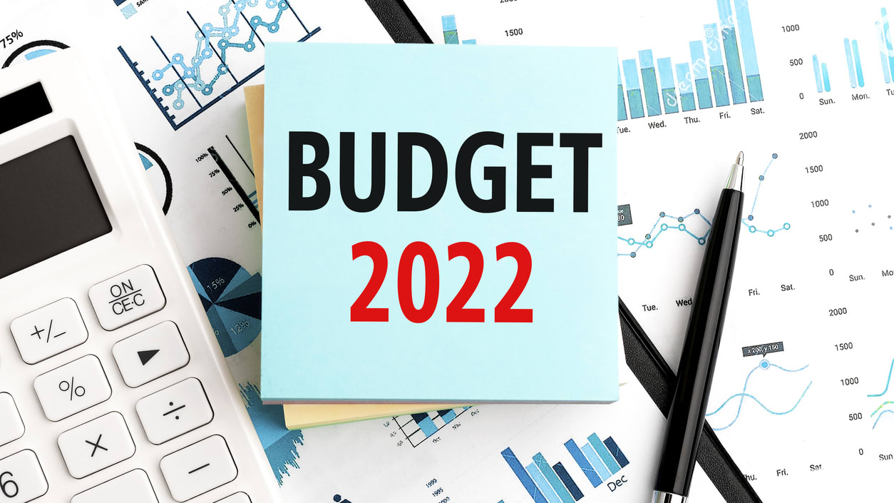 A note with the word budget 2021 on it sits on top of a calculator.