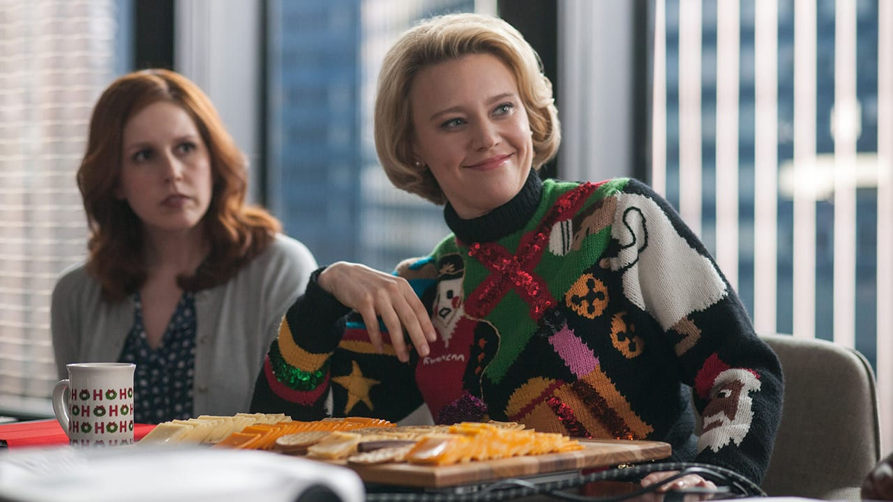 Two women sitting at a table with cheese and crackers.