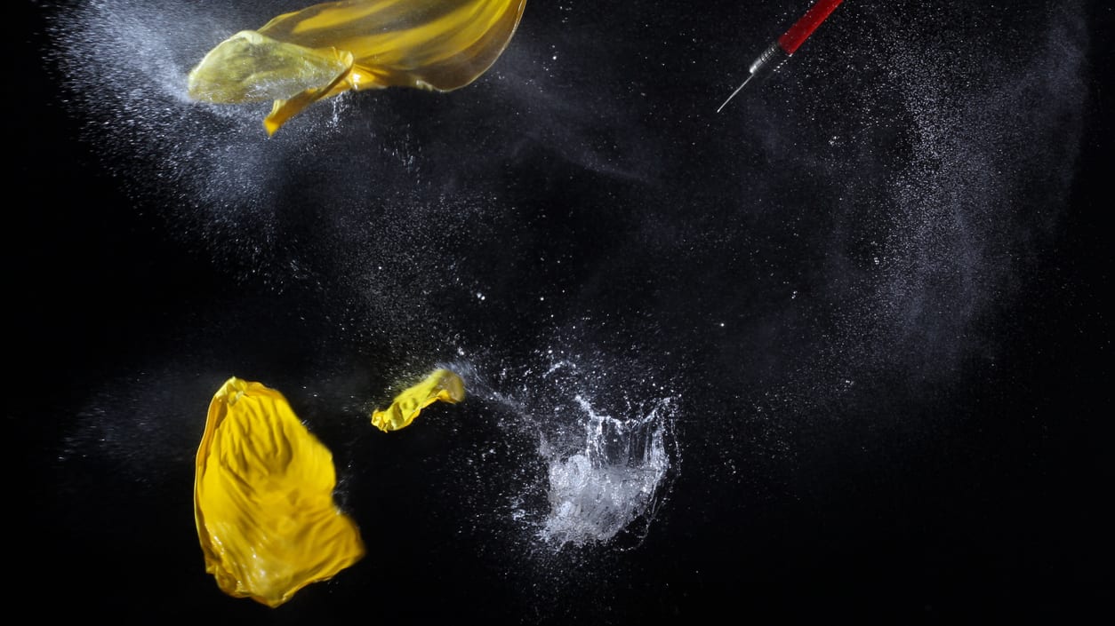 A yellow dart is thrown into a black background.