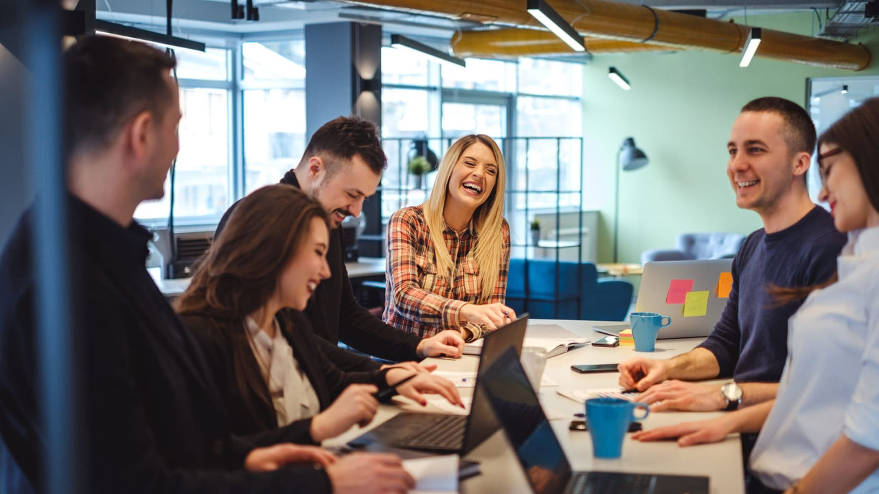 A group of people sitting around a table in an office.