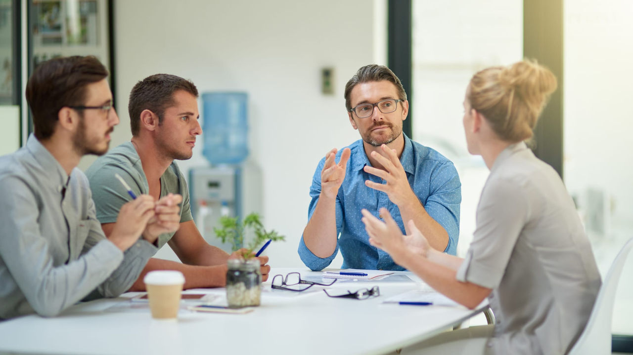 A group of people sitting around a table in an office.