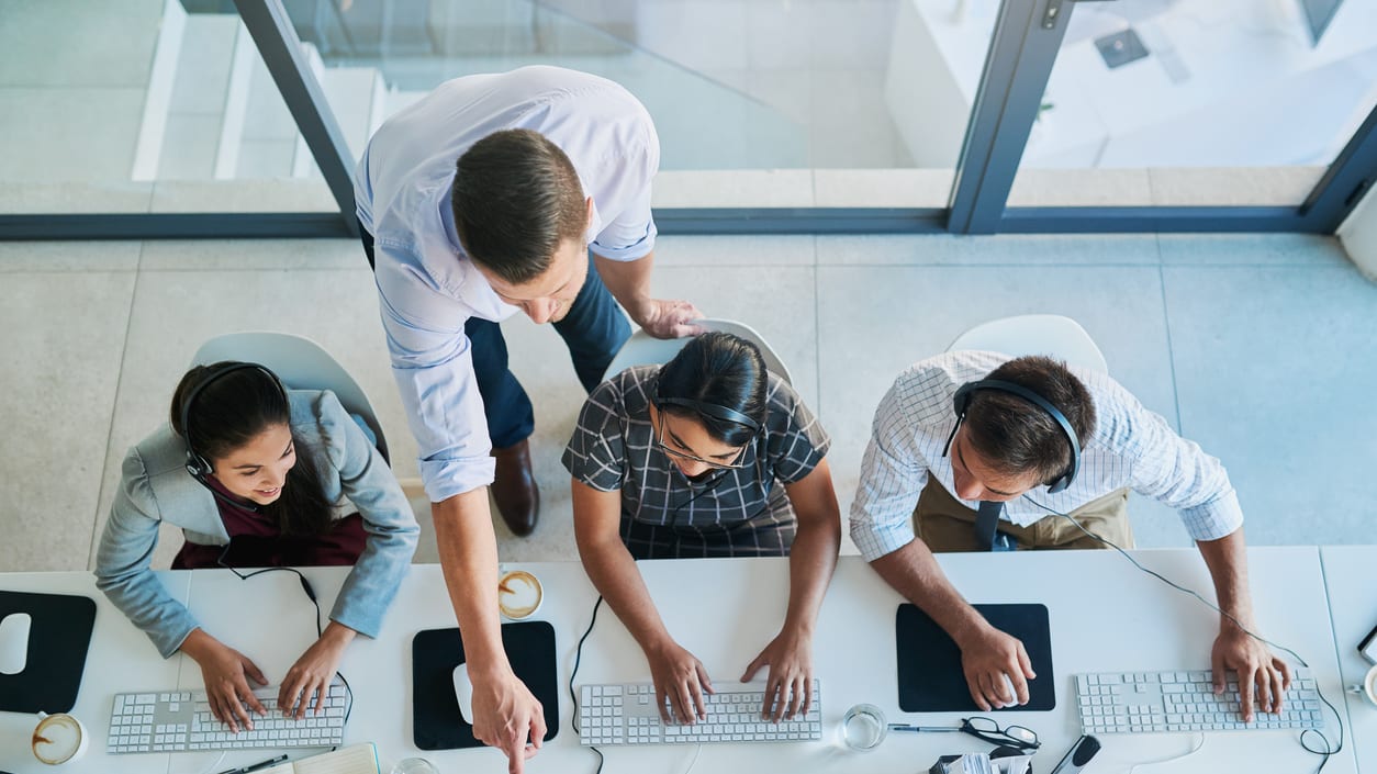 A group of people working on computers in an office.