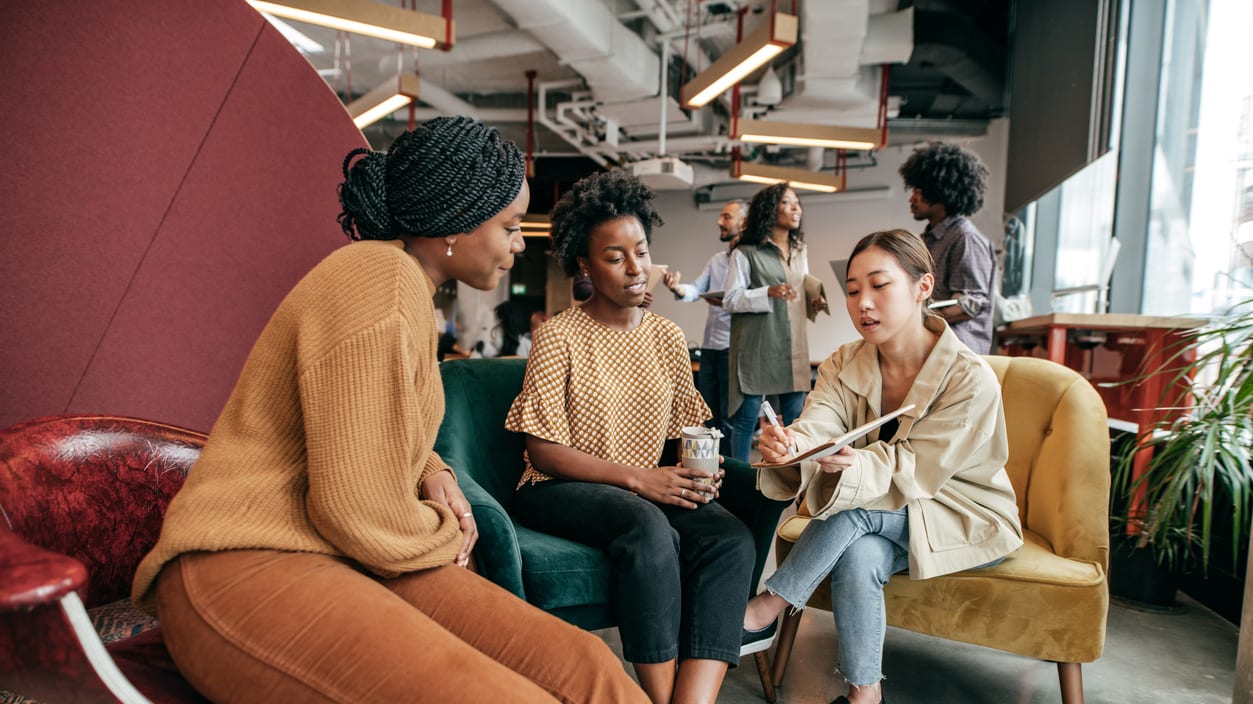 A group of women talking in an office.