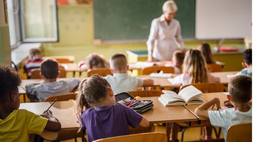 A group of children sitting at desks in a classroom.