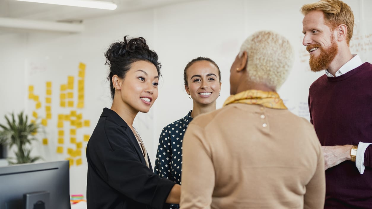 A group of people in an office talking to each other.