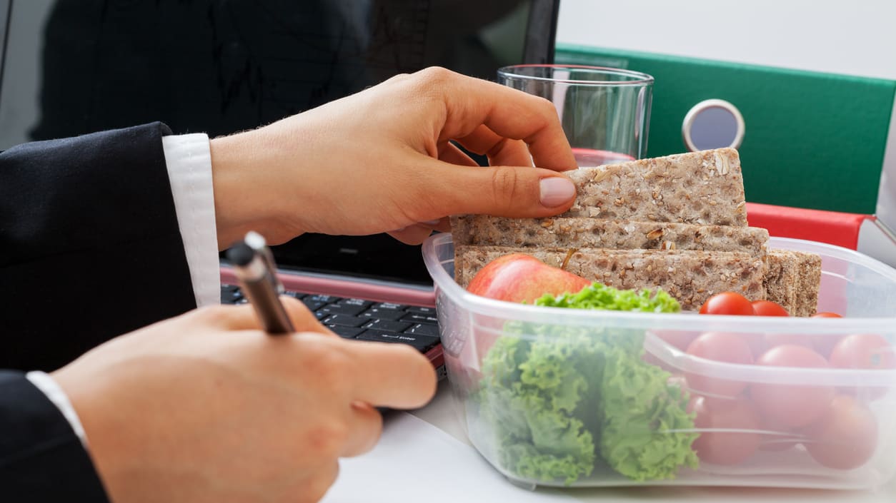 A person in a suit is holding a container of food.