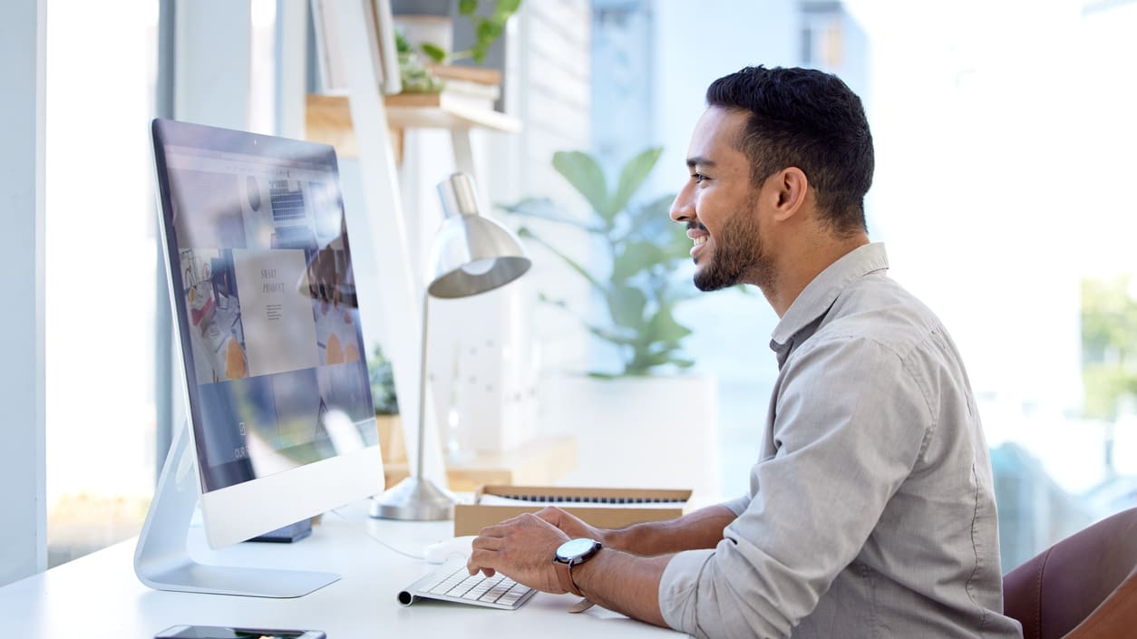 A man sitting at a desk using a computer.