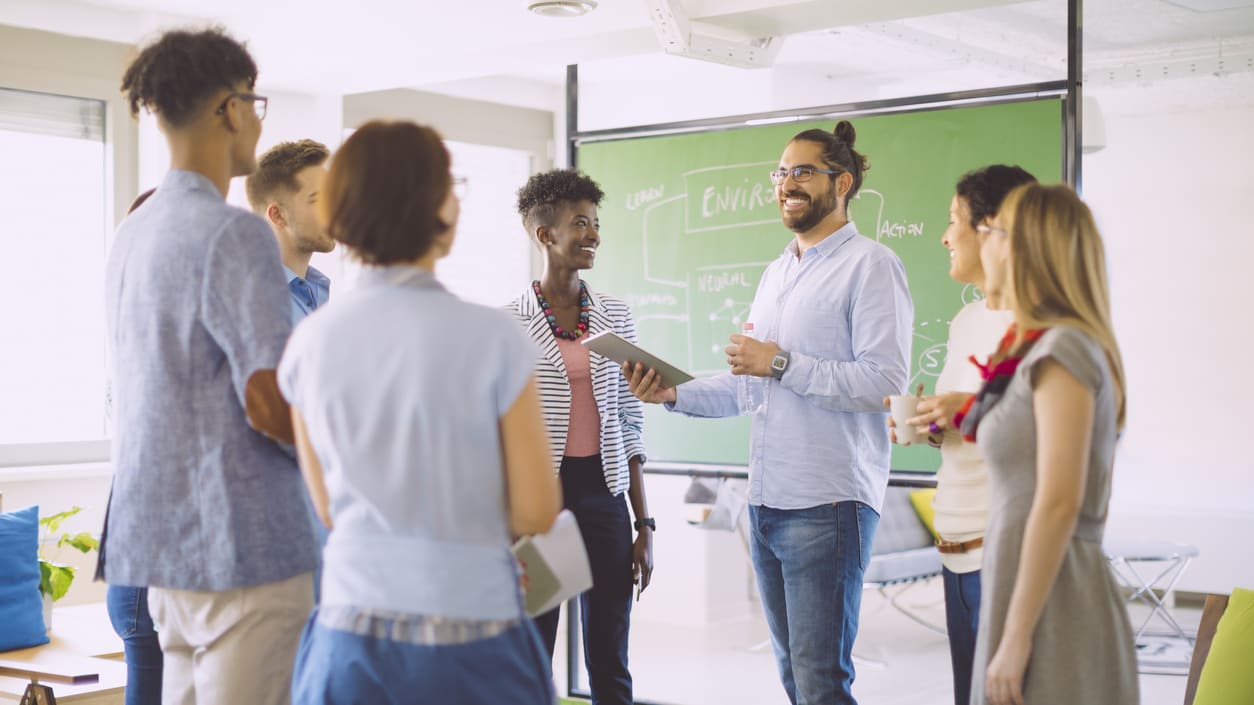 A group of people standing in front of a blackboard.