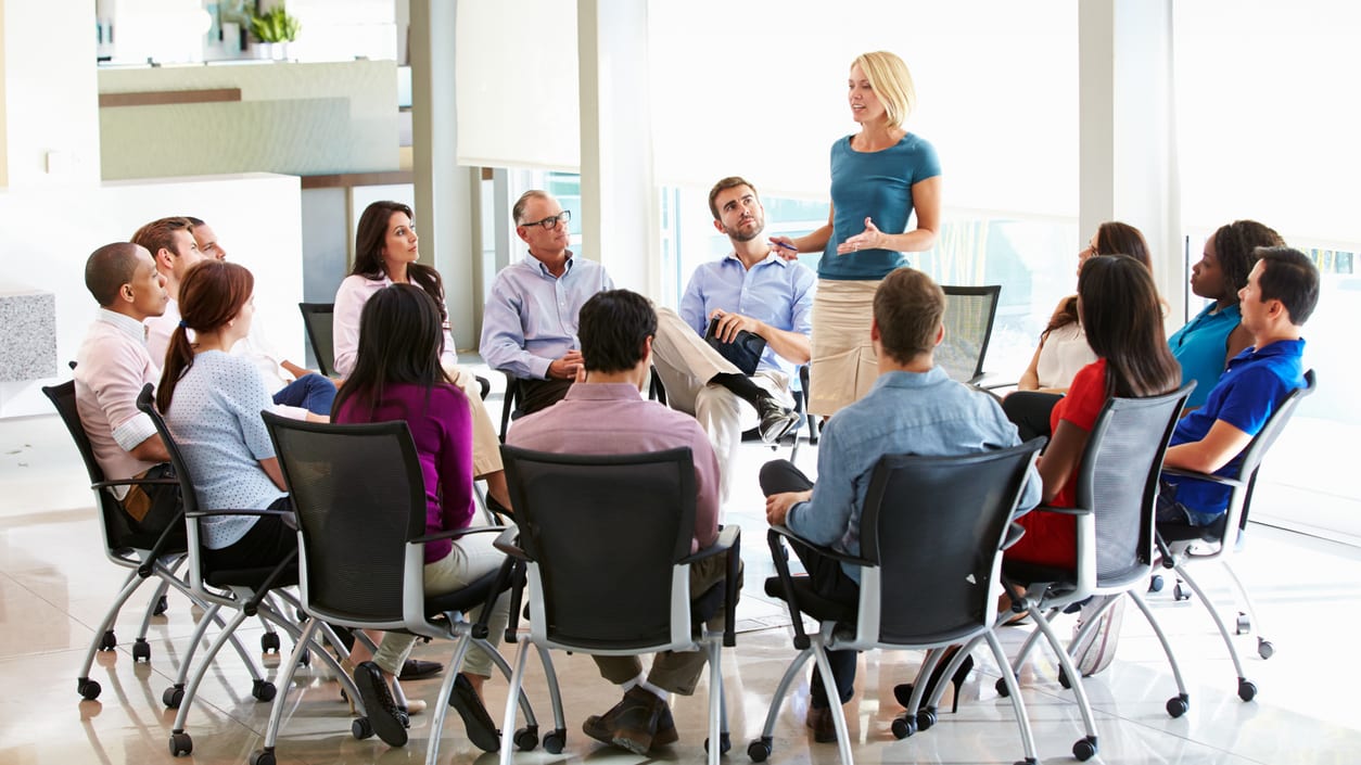 A group of people sitting around a table in a conference room.