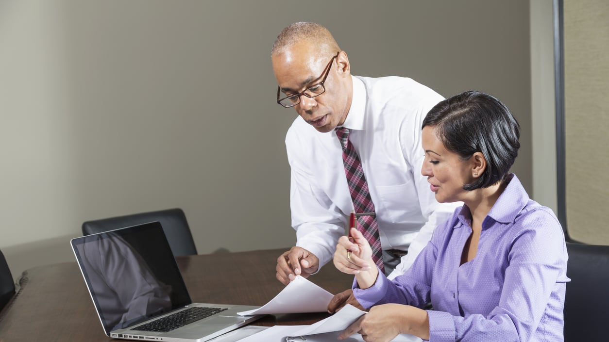 A man and woman working together at a conference table.