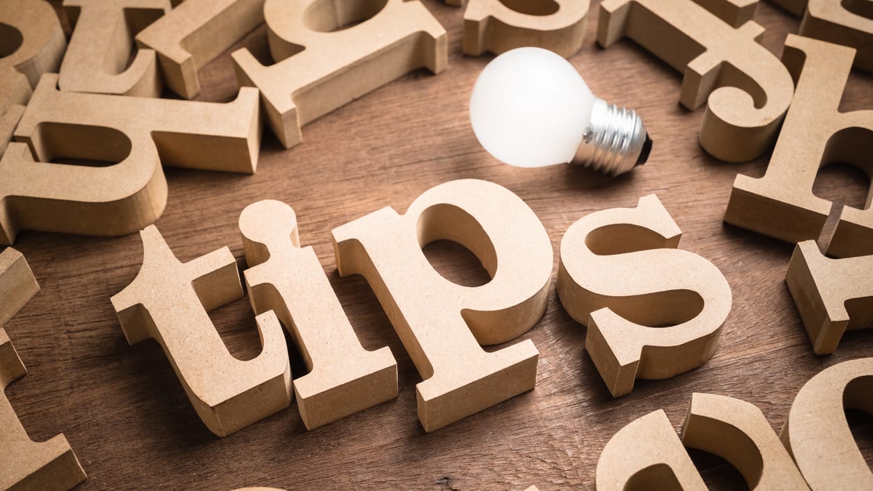 Tips spelled out on a wooden table with a light bulb.