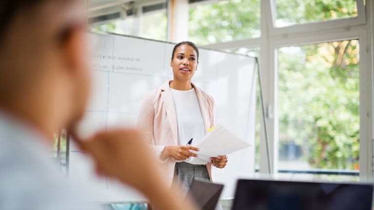 A woman is giving a presentation to a group of people.