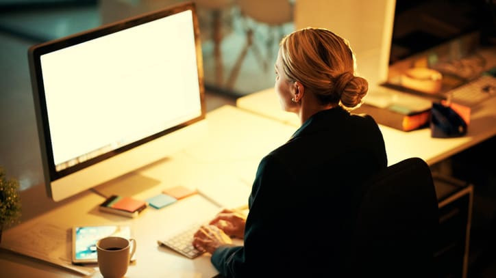 A woman sitting at a desk in front of a computer.