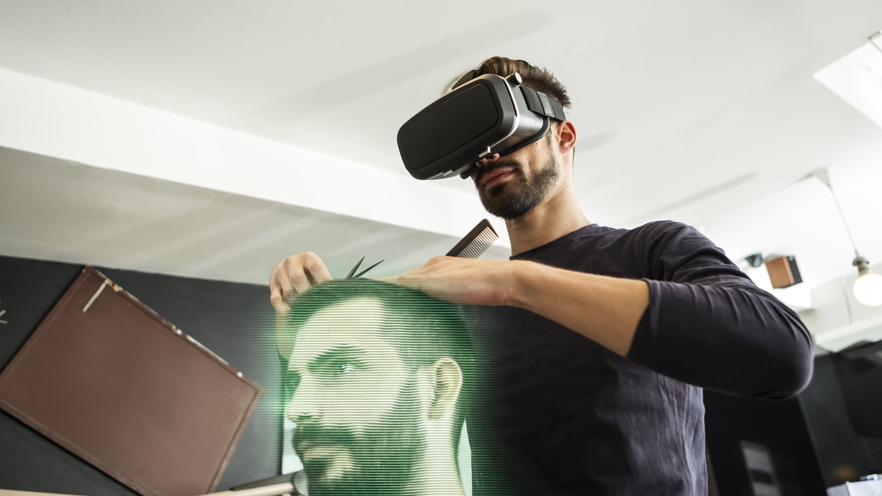 A man is getting his hair cut in a barber shop using a virtual reality headset.