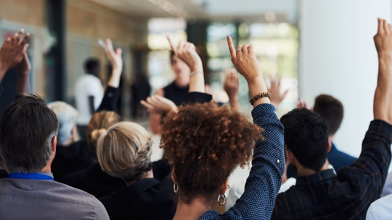 A group of people raising their hands in the air.