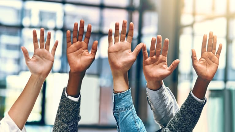 A group of people raising their hands in the air.