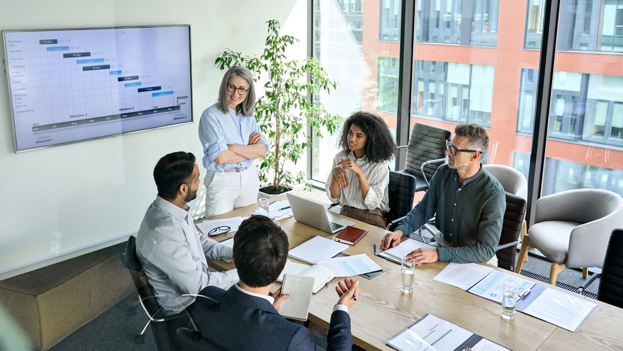 A group of people sitting around a table in a conference room.