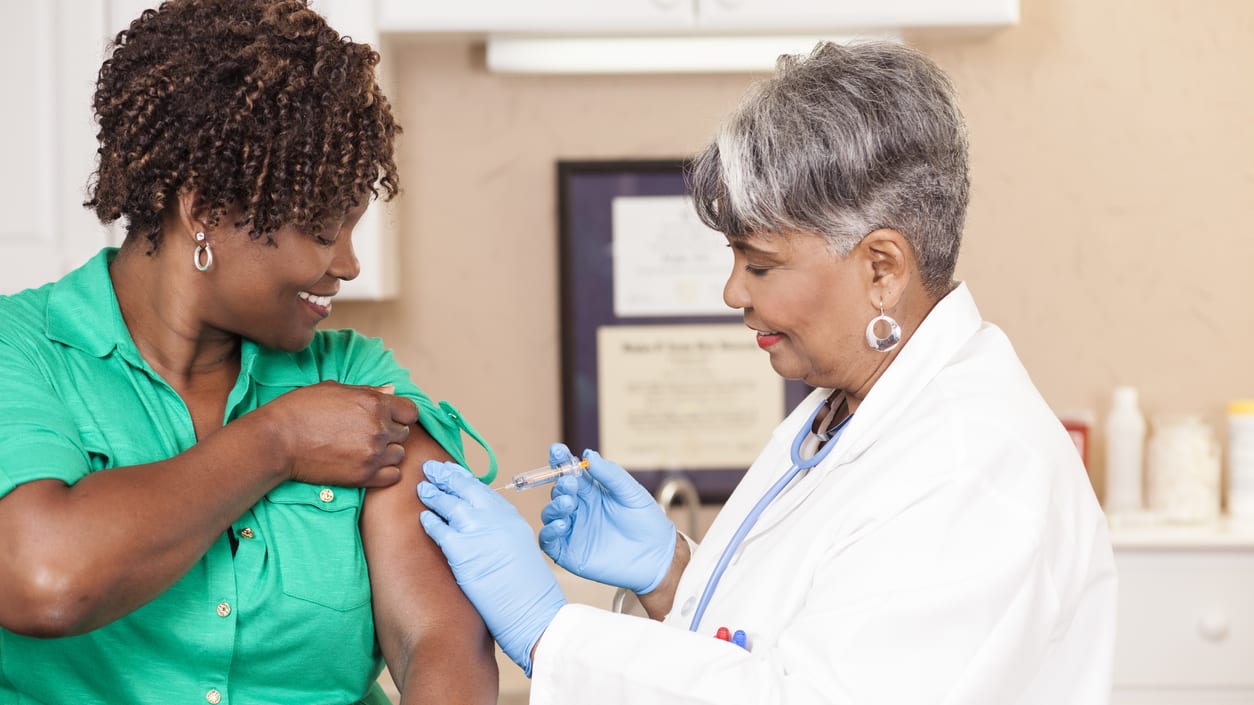 A woman is getting a vaccine from a doctor.