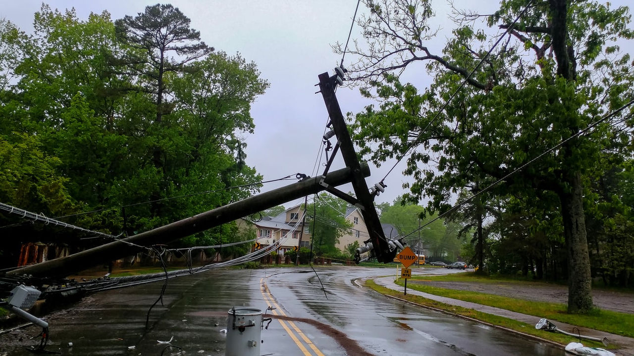 A fallen power pole on the side of a street.