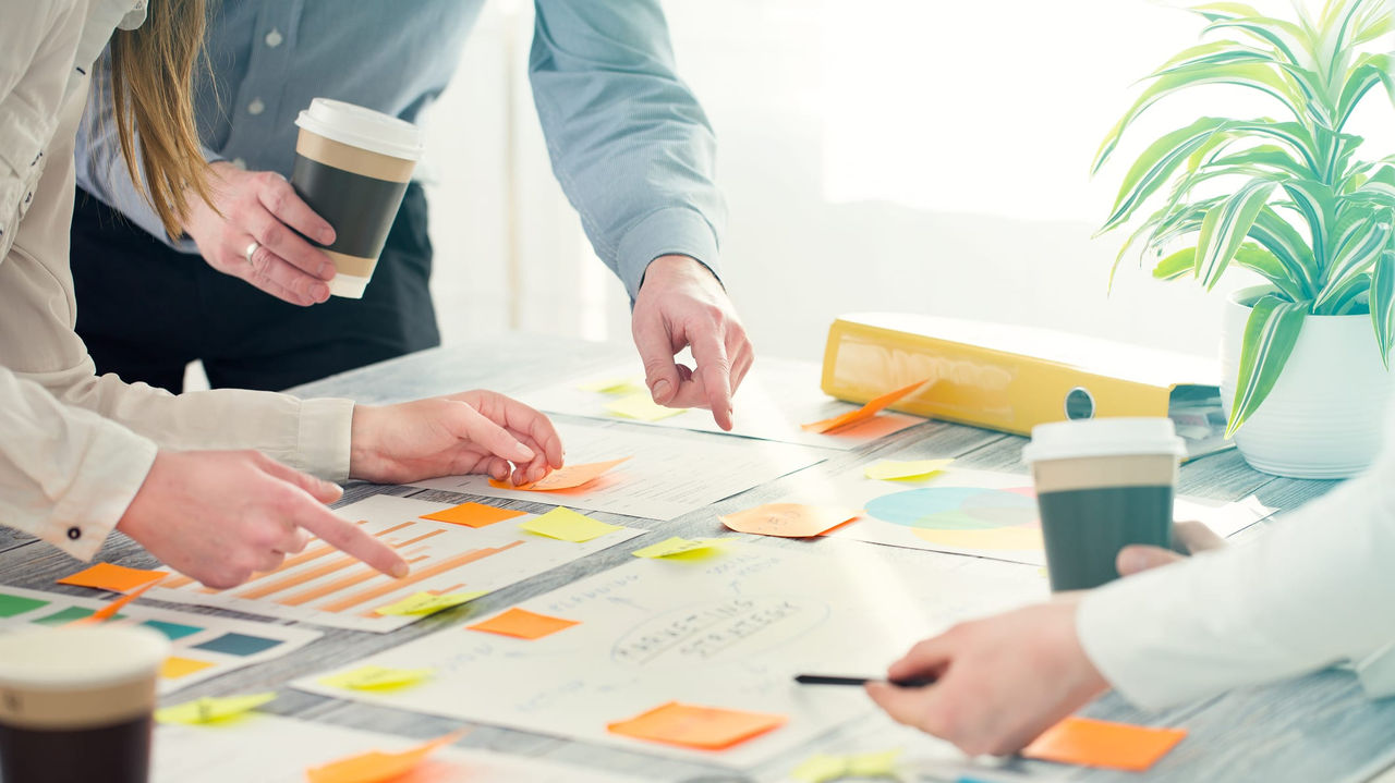 A group of people sitting around a table with sticky notes.