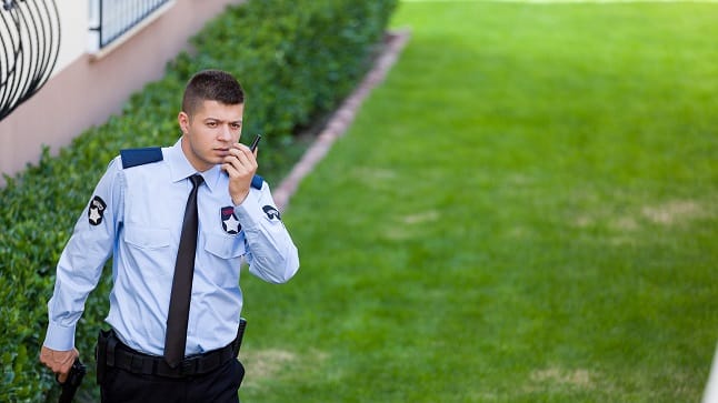 A man in a uniform talking on his cell phone.