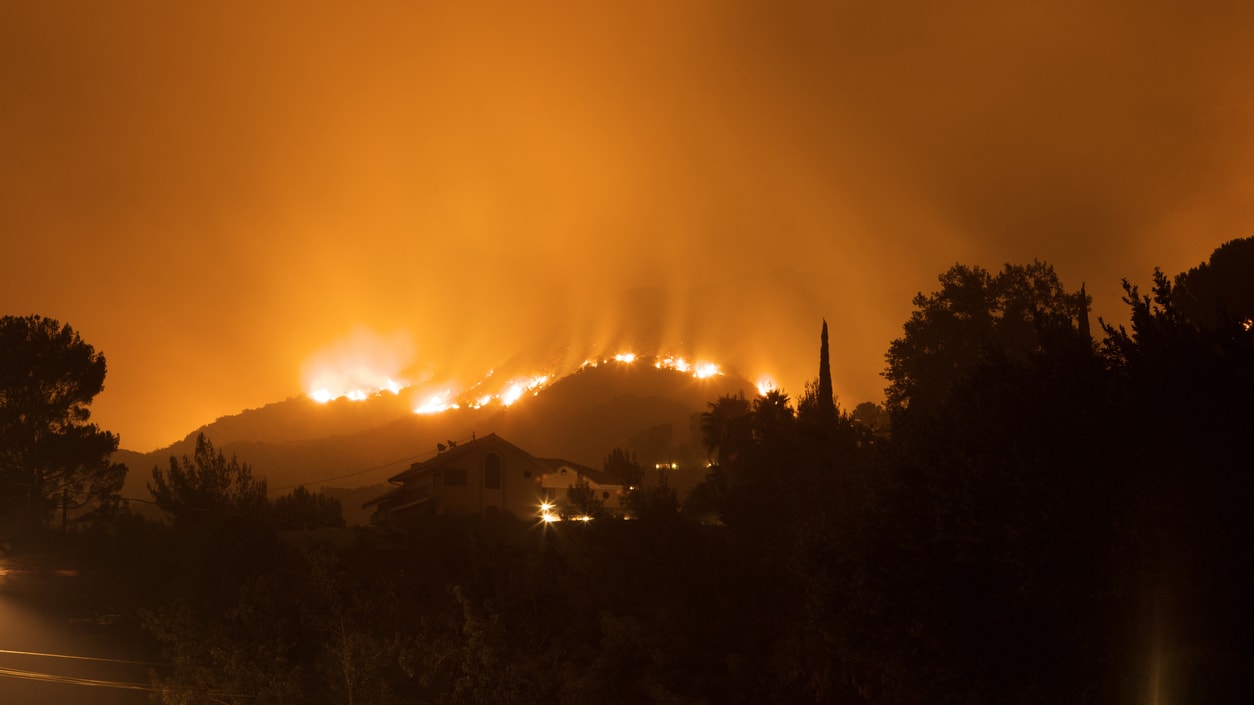 A fire burns on a hillside in california.