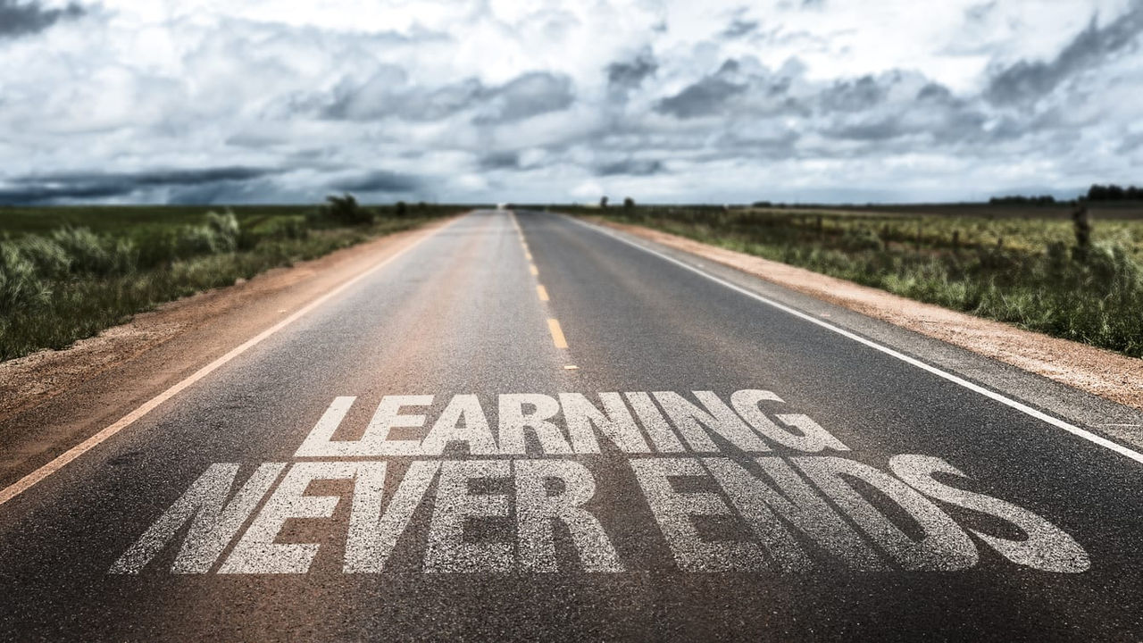 A road with the words learning never ends written on it.
