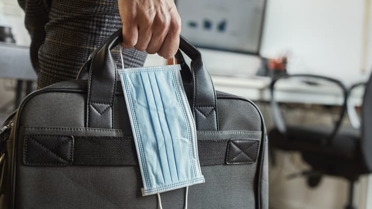 A man carrying a medical mask in a briefcase.