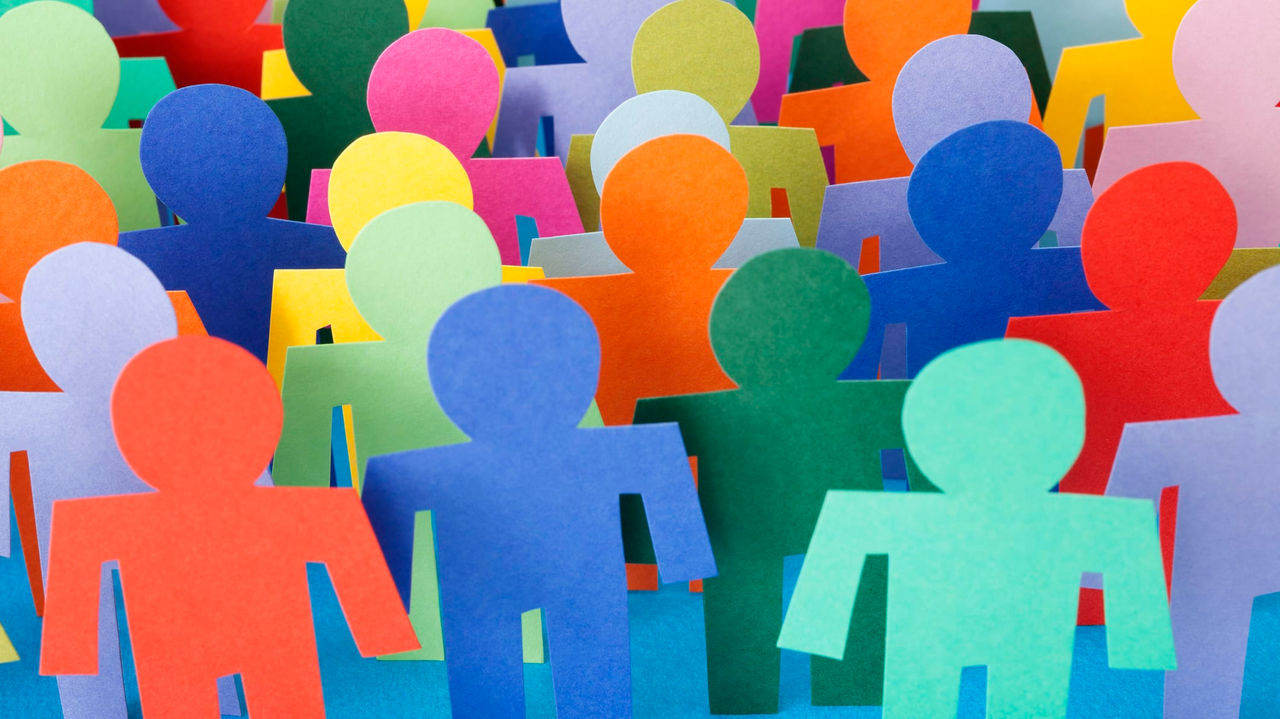 A group of colorful paper people standing in a row.