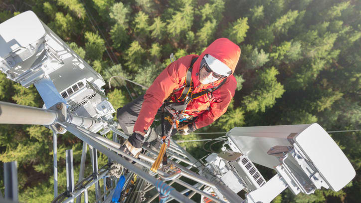 An aerial view of a worker on top of a tower.