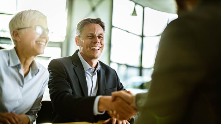 Two business people shaking hands during a meeting.
