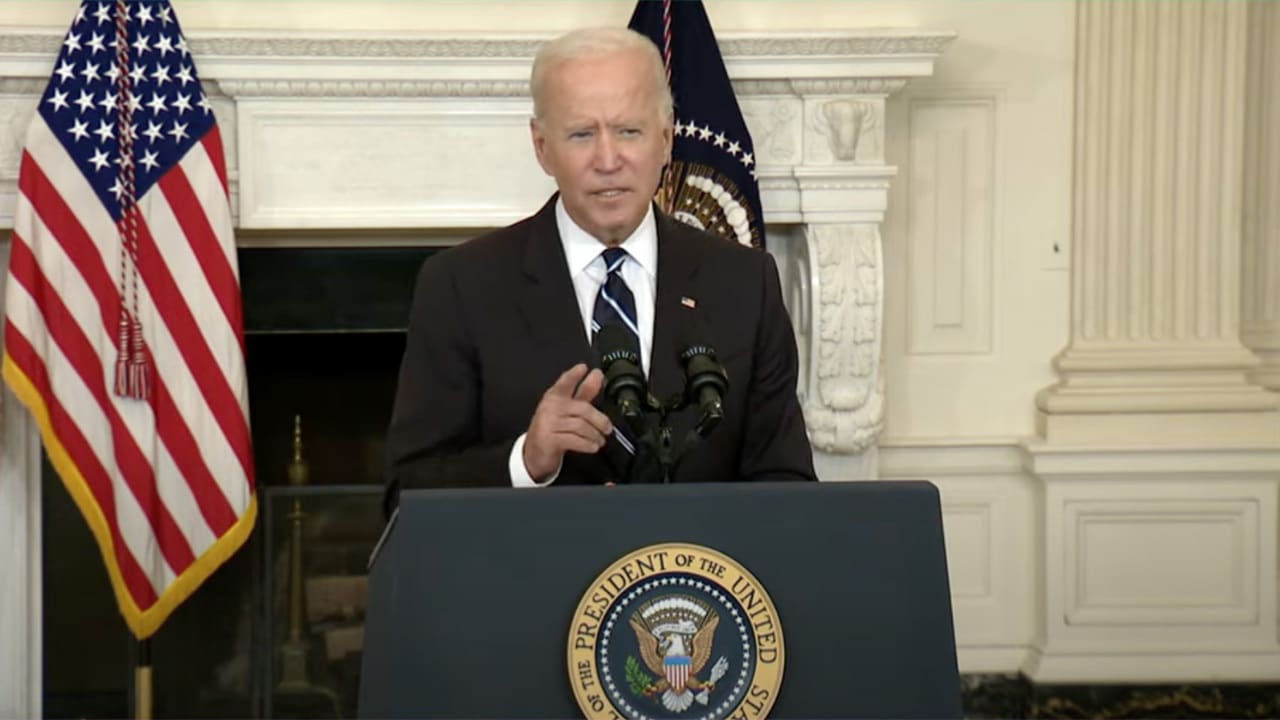 Joe Biden speaks at a podium in front of an american flag.