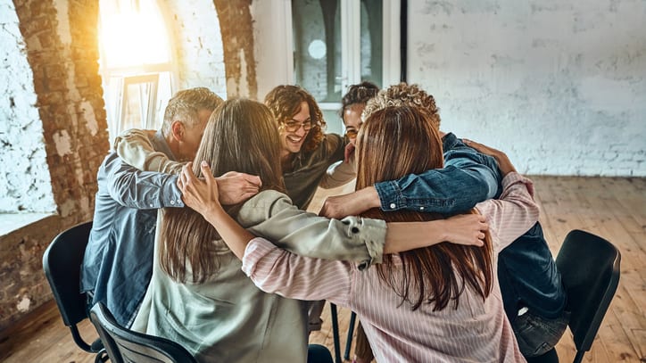 A group of people huddle around a table.