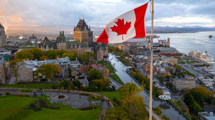 A canadian flag flies over the city of quebec.