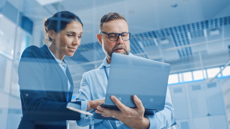 Two business people looking at a laptop.