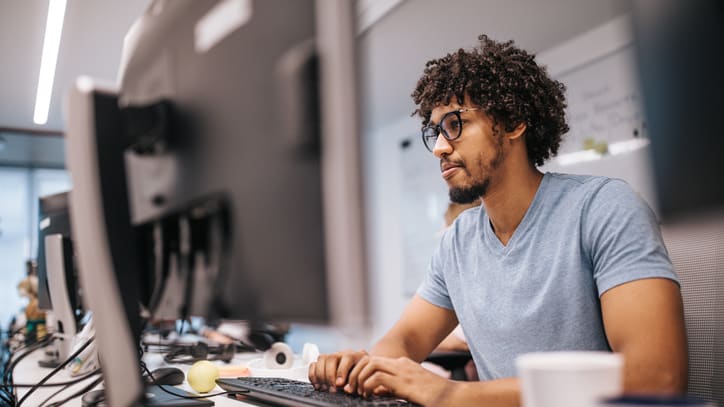 A man working on a computer in an office.